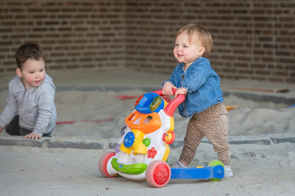 baby loopt met babywalker lente buiten