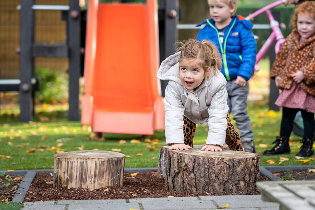 peuter handen op houtblok herfst buiten